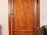 a tall wooden cabinet in the corner of a room
