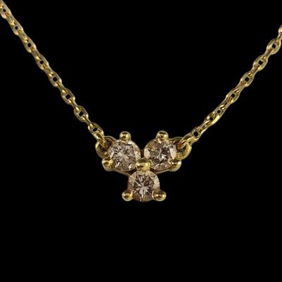 un collier en or orné de trois diamants sur fond noir