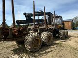 un gros tracteur garé sur un terrain en terre battue