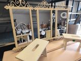 trois miroirs et un banc posés sur une table dans une pièce