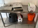 a metal table with two pans and a trash can on it