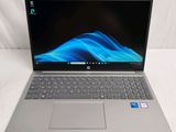 the laptop is open on a white surface with a blue wave on the screen