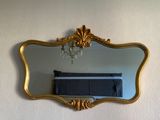 un miroir accroché au mur, avec un lit en arrière-plan