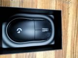 a black mouse in a black box on a wooden table