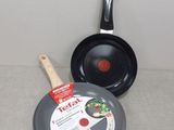 two pans and a frying pan sitting on a table