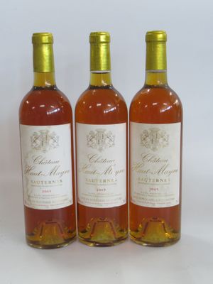 trois bouteilles de vin posées les unes à côté des autres sur une surface blanche