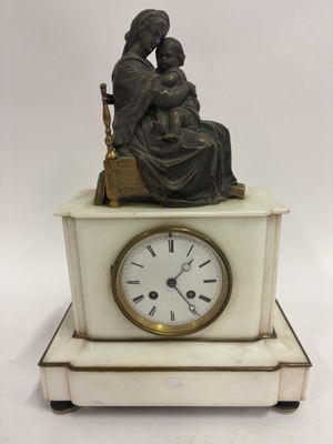une statue de femme assise au sommet d'une horloge