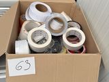many rolls of tape in a cardboard box on the floor
