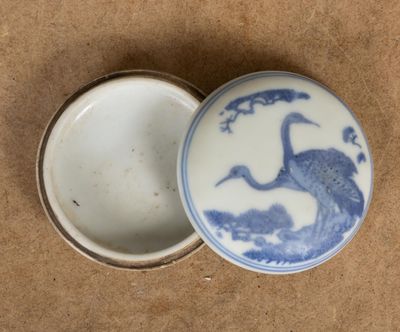un petit récipient bleu et blanc orné d'un oiseau