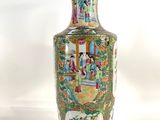 a vase with a painting on it sitting on a table