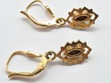 pair of gold earrings with garnets on them on a white surface