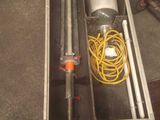 a metal box with a pipe and a hose in it