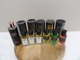 bottles of perfume are arranged on a wooden tray on a table