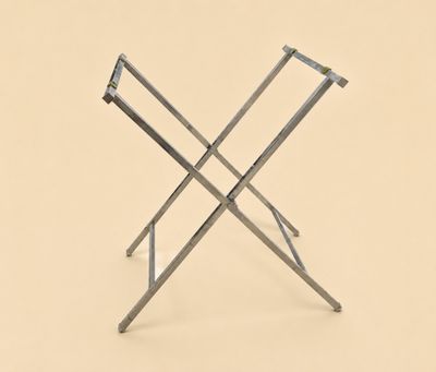 une petite table pliante à deux pieds, avec un plateau beige