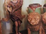 a statue of an angel holding a vase on a shelf