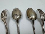 three silver spoons and two forks are lined up on a table