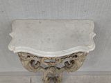 a white marble table with a marble top on the floor