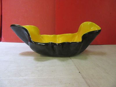 un bol noir et jaune posé par terre