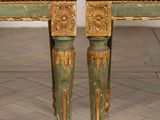 pair of green and gold painted chairs with floral upholstered cushions