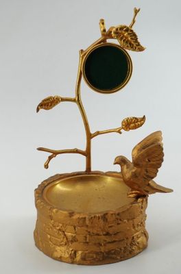 une assiette en or sur laquelle sont représentés un oiseau et un arbre