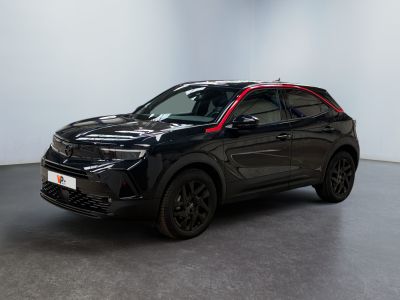 un SUV noir garé dans une pièce aux murs blancs