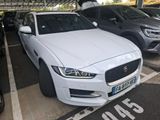a white jaguar car parked in a parking lot