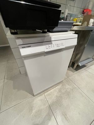 un lave-vaisselle blanc posé sur un plan de travail dans une cuisine
