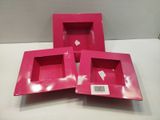 three pink boxes are sitting on a white surface with a price tag