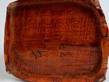 an old wooden box with writing on it sitting on a white surface