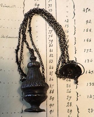 un collier auquel est suspendue une clochette, posé sur une table
