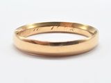 a close up of a gold ring on a white surface