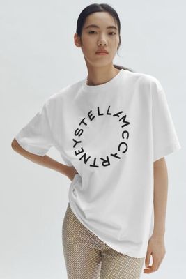 a woman wearing a white t - shirt with the words ' still thinking ' printed on it