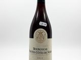 the bottle of wine is sitting on a white surface