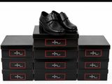 four black boxes with black shoes on top of them on a white surface
