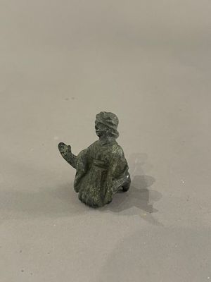 une petite figurine représentant un homme assis sur un skateboard