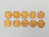 gros plan d'un paquet de pièces d'or sur une surface blanche
