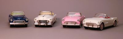 several toy cars are lined up in a row on a gray surface