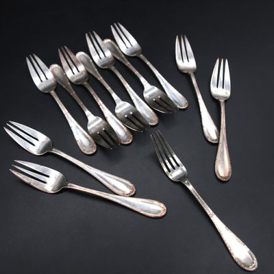 silver plated forks and spoons laid out on a black surface