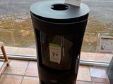 a black trash can sitting in front of a window