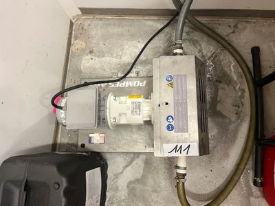 un chauffe-eau posé au sol à côté d'un tuyau d'arrosage