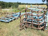 a blue plow that is sitting in the grass