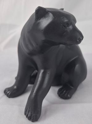 a black bear statue sitting on a white surface