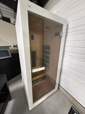un sauna installé dans un coin d'une pièce équipée d'une télévision