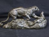 statue of a tiger and a dog on a rock on a black background