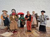 sept figurines représentant des personnes vêtues de costumes différents