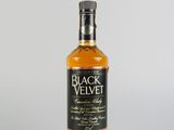 une bouteille de whisky « Black Velvet » posée sur une surface blanche