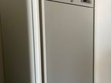 a refrigerator in the corner of a room with a white wall