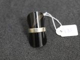 une bague posée sur une table à côté d'une étiquette de prix