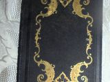 a black book with gold designs on it on a table