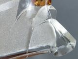 a glass sculpture of a bird with a yellow face